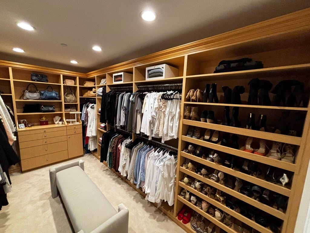 Alyssa Lane - Wardrobe Refinement: 
Walk-in closet with wooden shelves, clothes, and shoes.