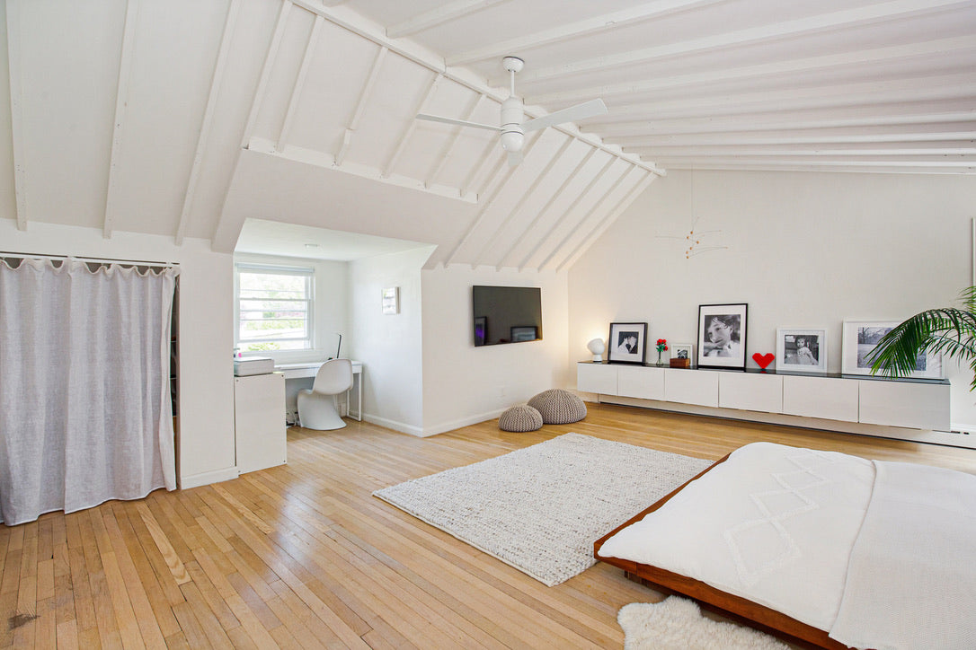 Seacord House - Full Home Reset: 
Modern living room with wooden floor, white walls, and a large bed.