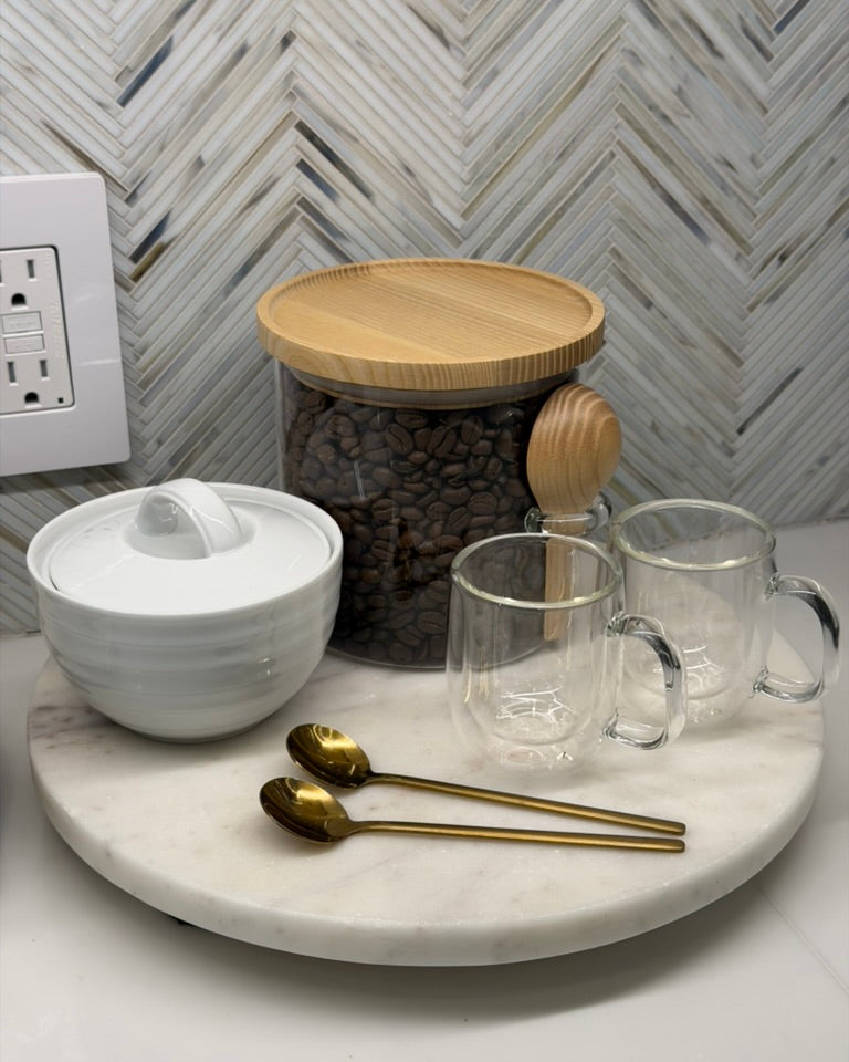 Alyssa Lane - Kitchen Refresh:  
Coffee-making setup with a jar of coffee beans, cups, and utensils on a marble tray.
