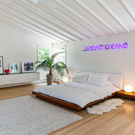 Modern bedroom with a bed, rug, and decorative elements.