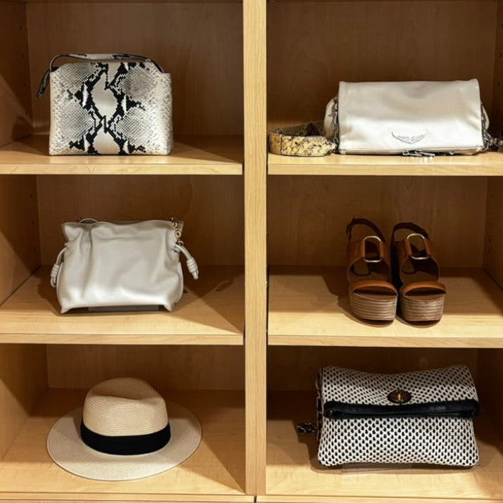 Wooden shelf with various handbags and shoes on a neutral background