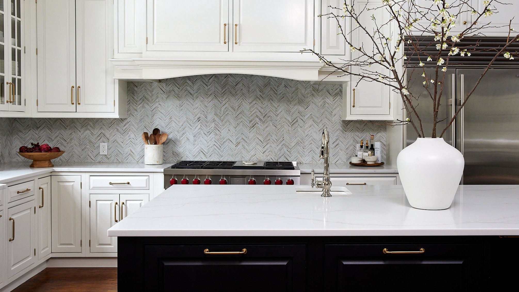  Modern kitchen with white cabinets, marble countertop, and decorative elements. 