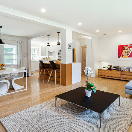 Seacord House - Full Home Reset: 
Modern living room with a black coffee table, rug, and kitchen in the background.